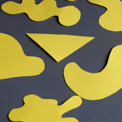 Zdjęcie przedstawia żółte kształty położone na szarym papierze.