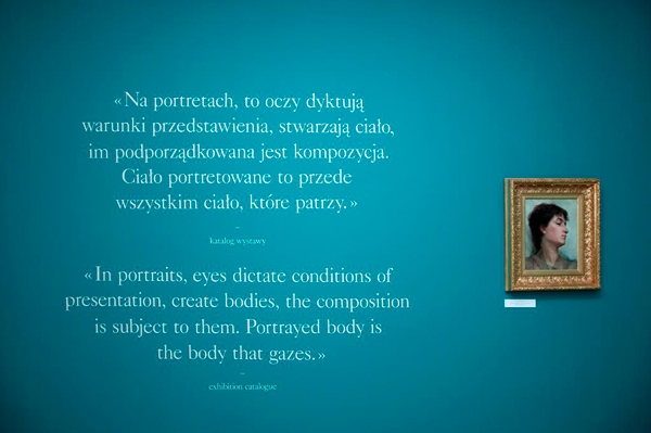 Turkusowa ściana, na której znajdują się tekst i obraz - portret kobiety, w złotej ramie po prawej stronie