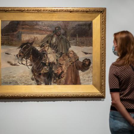 Kobieta przyglądająca się jednemu z obrazów.