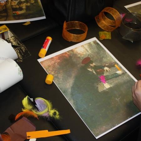 Zbliżenie na jedną z wykonywanych prac plastycznych. Dookoła materiały - kleje, piórka, kolorowy papier.