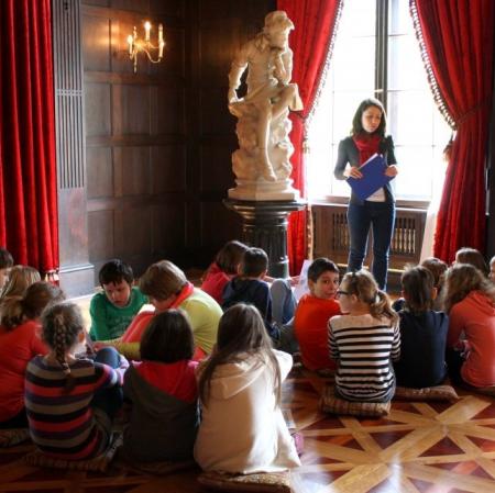 Uczestnicy warsztatu siedzą przy rzeźbie młodego Kolumba.