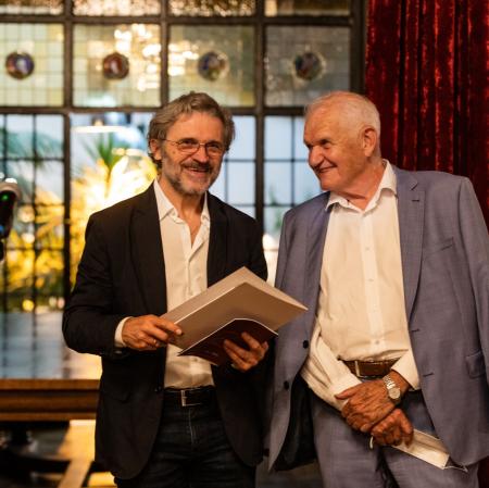 Dwóch mężczyzn. Stoją obok siebie, uśmiechają się.