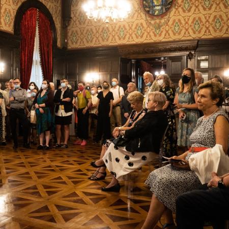 Publiczność w sali balowej: kilkadziesiąt osób, większość stoi, niektórzy siedzą