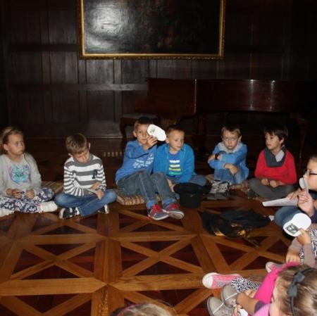 Sala balowa. Uczestnicy warsztatów siedzą w kręgu. Losują cytaty z XIX wiecznych poradników.