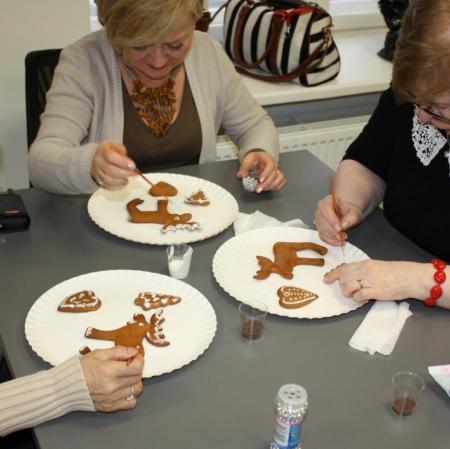 Uczestniczki warsztatów dekorują bożonarodzeniowe pierniki.