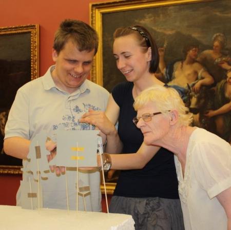 Uczestnicy warsztatu "Pałac Herbsta w kilku odsłonach" odwzorowujący jeden z obrazów za pomocą papierowych kukiełek.