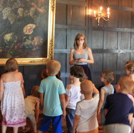 Przedszkolaki na warsztatach Pałacowa menażeria na sali balowej w Muzeum Pałac Herbsta szukają zwierzaków. Na obrazie Giovanniego Battisty Ruoppolo "Alegoria zbiorów jesiennych" dzieci znalazły żółwia.