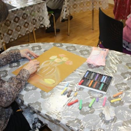 Uczestniczka warsztatów wykonująca martwą naturę pastelami.