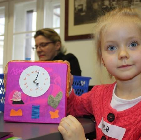 Uczestniczka warsztatów z wykonanym przez siebie zegarem.