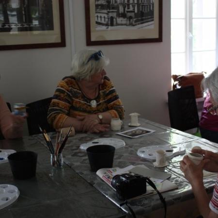 Uczestnicy podczas warsztatów dekorują filiżanki w stylu empirowym