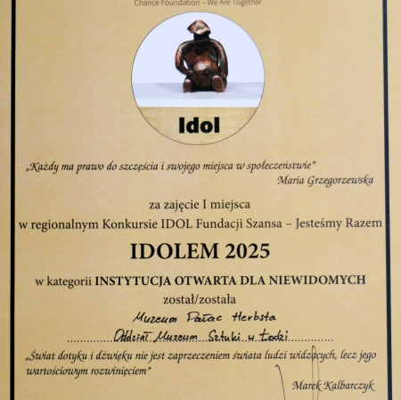 Dyplom w kolorze jasnego beżu z czarną ramką ozdobną, przyznany przez Fundację Szansa – Jesteśmy Razem w ramach regionalnego Konkursu IDOL.  Tekst główny informuje, że:  Za zajęcie I miejsca w regionalnym Konkursie IDOL Fundacji Szansa – Jesteśmy Razem IDOLEM 2025 w kategorii INSTYTUCJA OTWARTA DLA NIEWIDOMYCH został/została Muzeum Pałac Herbsta – Oddział Muzeum Sztuki w Łodzi.
