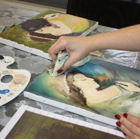 Zbliżenie na dłonie uczestniczki oraz powstającą prace malarską