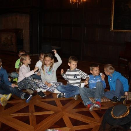 Sala balowa. Uczestnicy warsztatów siedzą w kręgu. Losują cytaty z XIX wiecznych poradników.