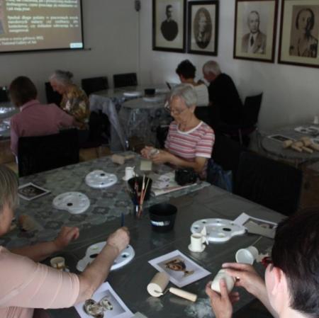 Uczestnicy podczas warsztatów dekorują filiżanki w stylu empirowym