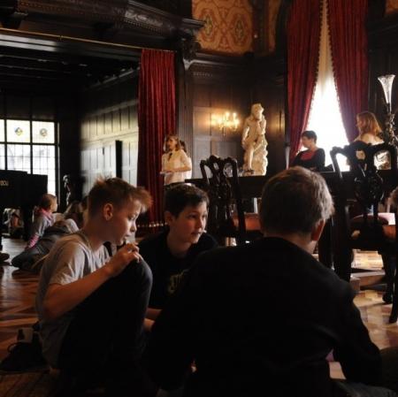 Uczestnicy zajęć podczas wykonywania plakatów w sali balowej