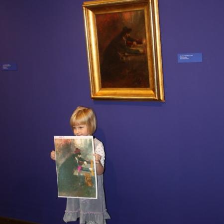 Uczestniczka warsztatów prezentuje swoją pracę pod obrazem "Pisarz Tory" Maurycego Gottlieba.