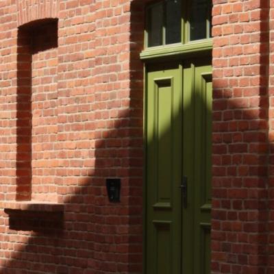 Zdjęcie zielonych drzwi do budynku z cegły.