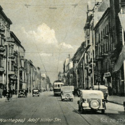 Czarno-białe zdjęcie ulicy z samochodami i tramwajem
