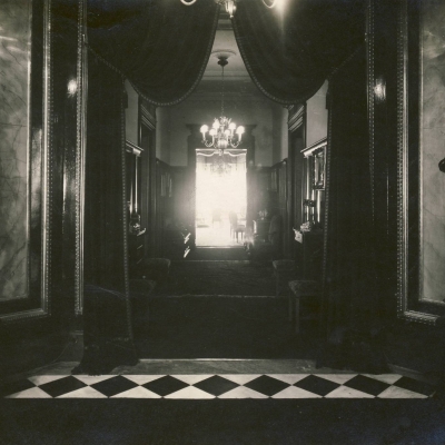 czarno-białe zdjęcie przedstwia westybul, gdzie dwóch rycerzy trzyma latarnie.