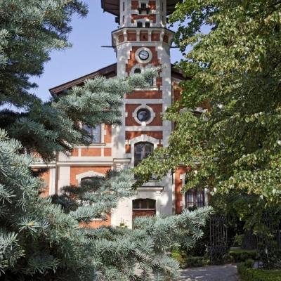 Wieża dawnej powozowni za zielonymi drzewami